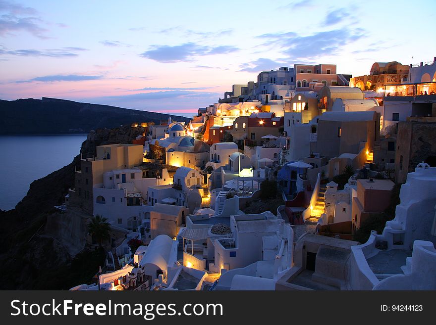 A panoramic view of a town in Santorini at dusk. A panoramic view of a town in Santorini at dusk.