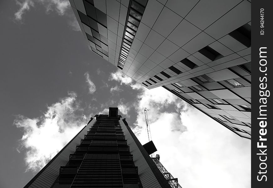 A low-angle view of buildings in a city in black and white. A low-angle view of buildings in a city in black and white.