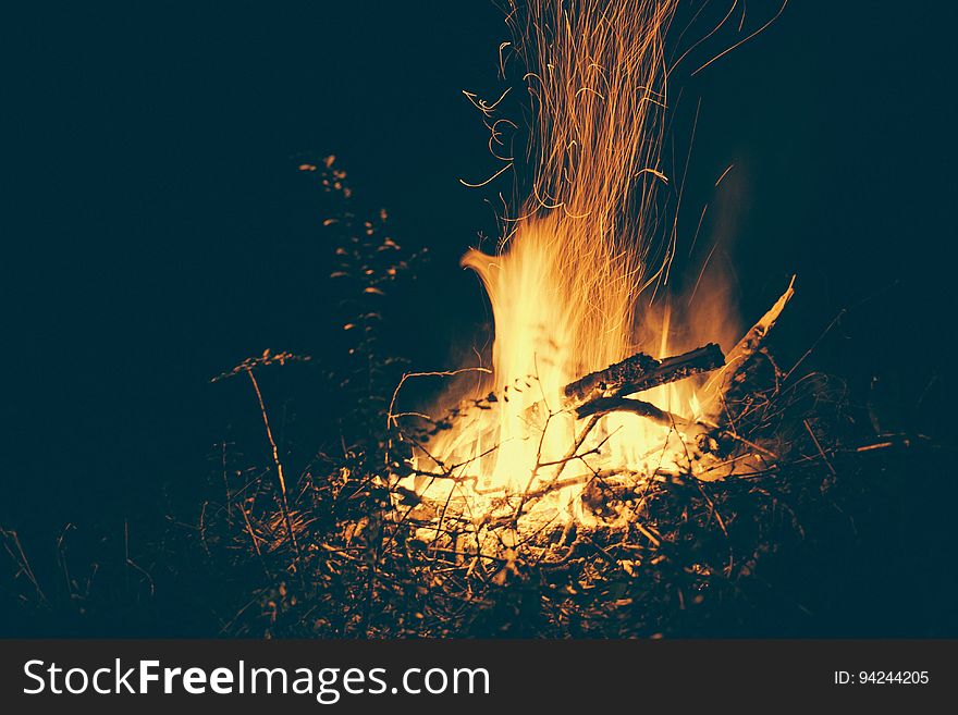 A close up of a bonfire sparkling in the dark.