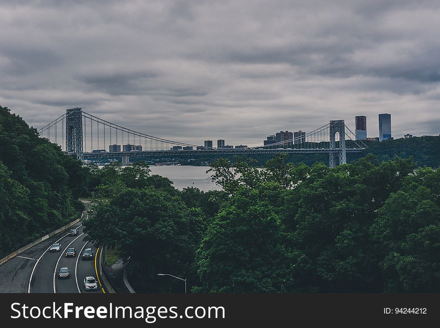 A cityscape on a gloomy day with a freeway connecting to a bridge. A cityscape on a gloomy day with a freeway connecting to a bridge.