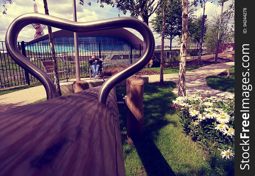 A park with a bench seen through a metal frame. A park with a bench seen through a metal frame.