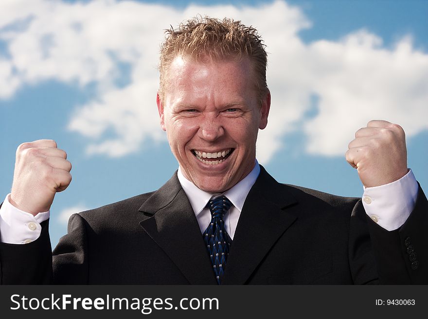 A businessman celebrates success with his arms in the air. A businessman celebrates success with his arms in the air