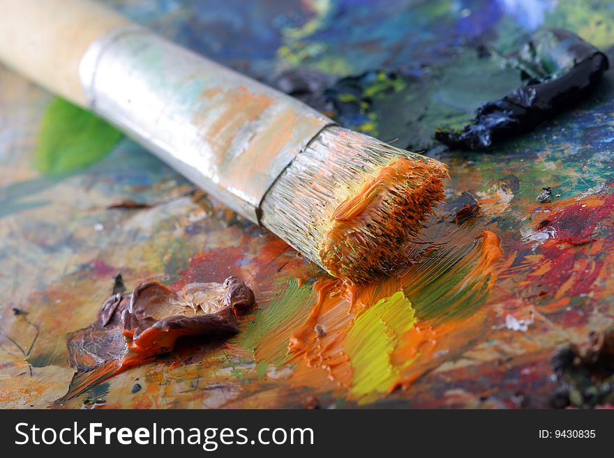 Bright colored paint with a brush on a palette. Bright colored paint with a brush on a palette.