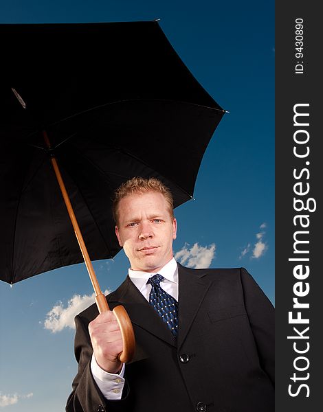 A man holds an umbrella on a sunny clear day. A man holds an umbrella on a sunny clear day