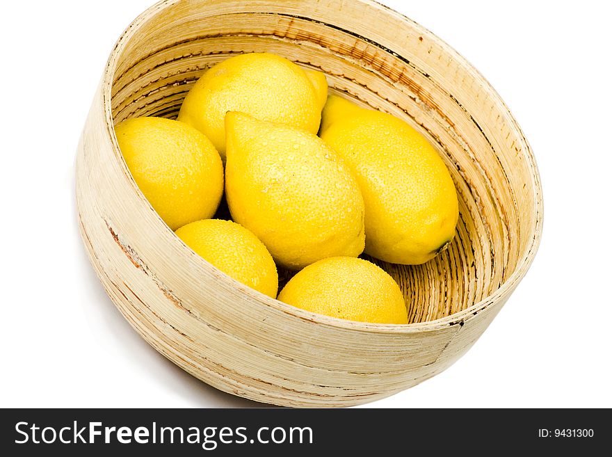 A wooden bowl of fresh organic lemons. A wooden bowl of fresh organic lemons