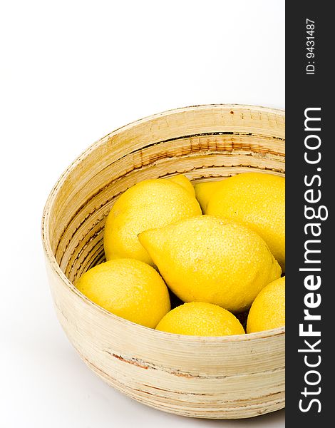 A wooden bowl of fresh organic lemons. A wooden bowl of fresh organic lemons