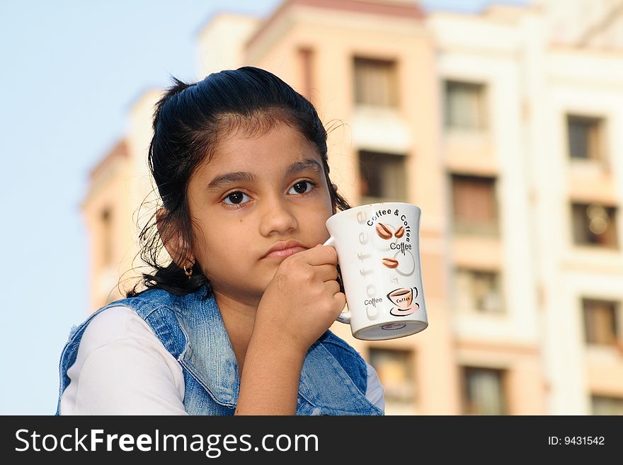 A girl in deep thinking over her problem over a cup of coffee. A girl in deep thinking over her problem over a cup of coffee.