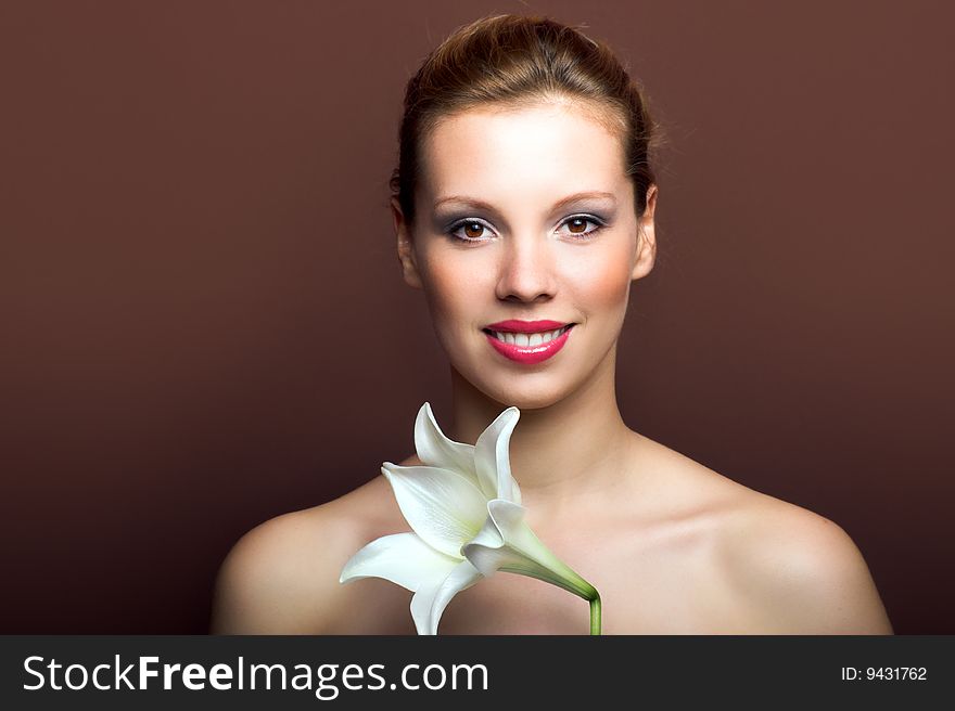 Beauty portrait of a young woman with a lily flower. Beauty portrait of a young woman with a lily flower