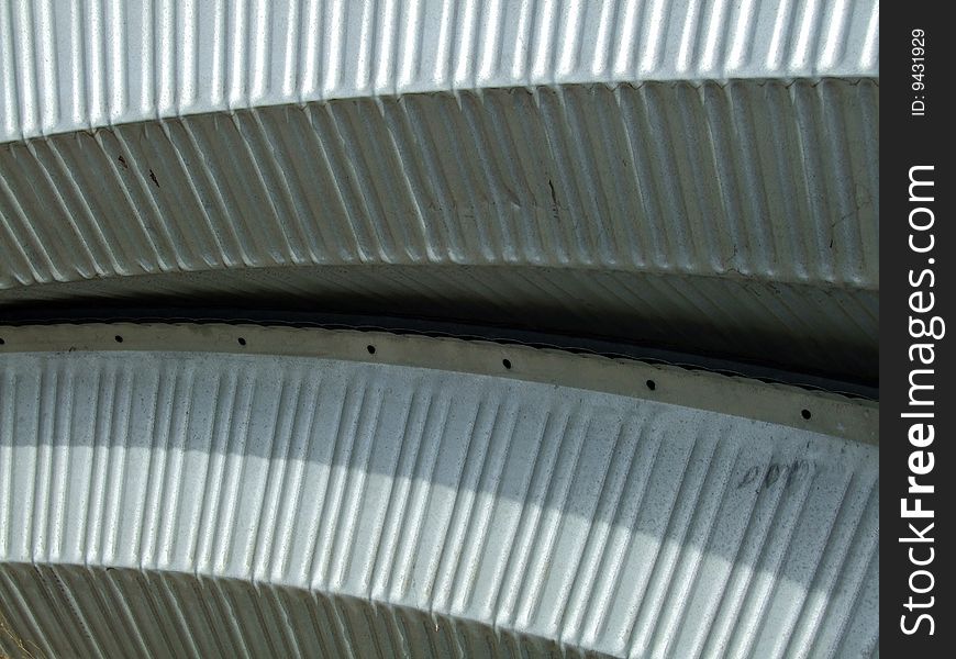 Curved corrugated steel material for a Quonset hut roof and siding.