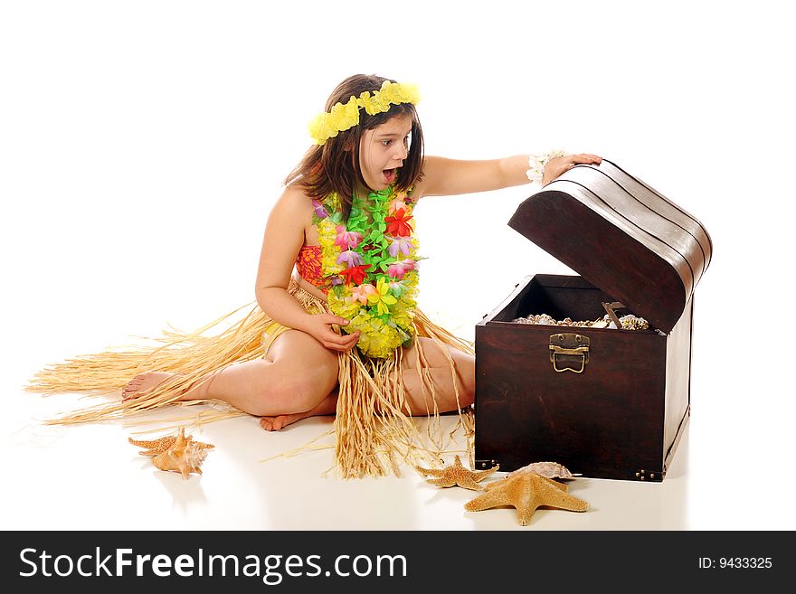 A preteen hula girl delighted with the treasures found an old pirate trunk. Isolated on white. A preteen hula girl delighted with the treasures found an old pirate trunk. Isolated on white.