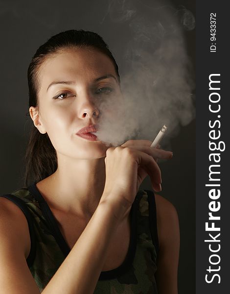 girl in camouflage with cigarette, studio shot. girl in camouflage with cigarette, studio shot