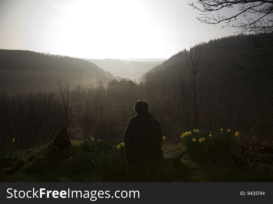 Man at sunrise looking out at countryside veiw