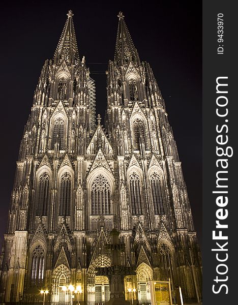 Main towers and portal of Dom in Cologne at night lighting.