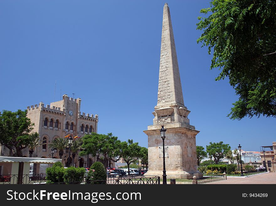 Obelisk and a historic building in the square in the town in Balearic islands