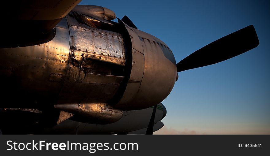 Sunlit old aircraft engine against setting sunlit sky. Sunlit old aircraft engine against setting sunlit sky
