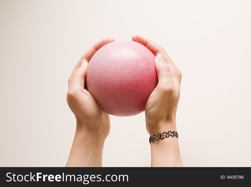 Two female hands holding a red ball. Two female hands holding a red ball