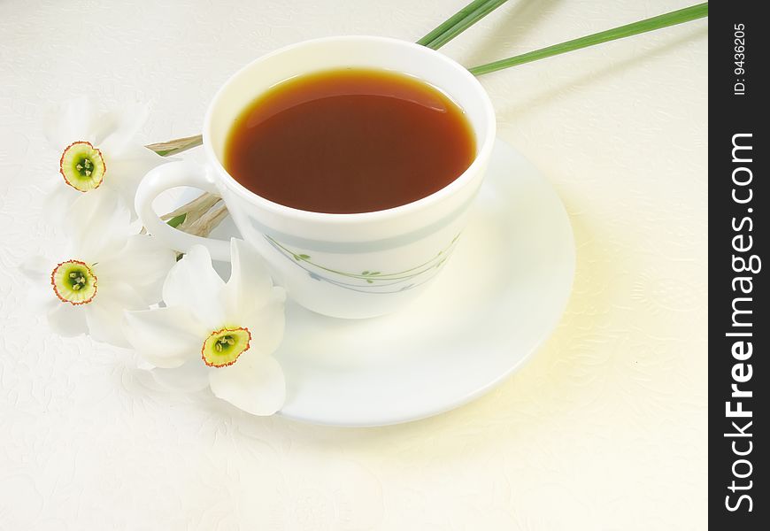 Cup of tea and narcissus flowers