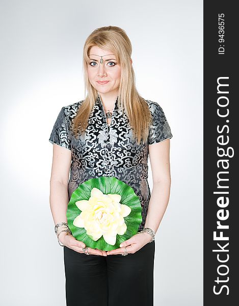 Attractive woman with lotus flower, studio shot