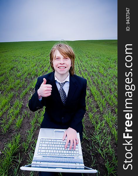 Smiling businessman with laptop outdoors