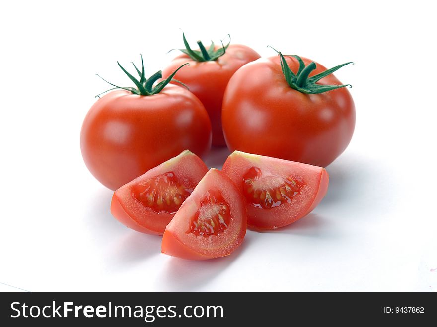 Red tomatoes and slices on a white background