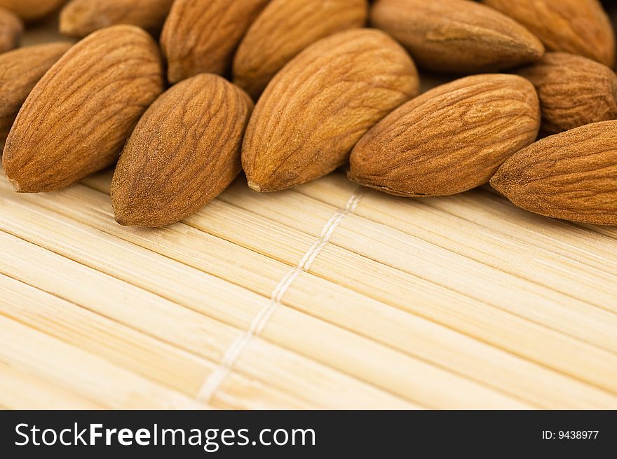 Group of almonds on a bamboo mat, close up. Group of almonds on a bamboo mat, close up.