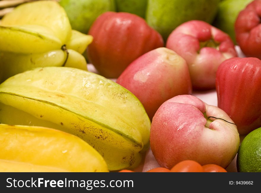 Tropical fruits in a basket, including starfruit; mango, lime and pink guava. Tropical fruits in a basket, including starfruit; mango, lime and pink guava.