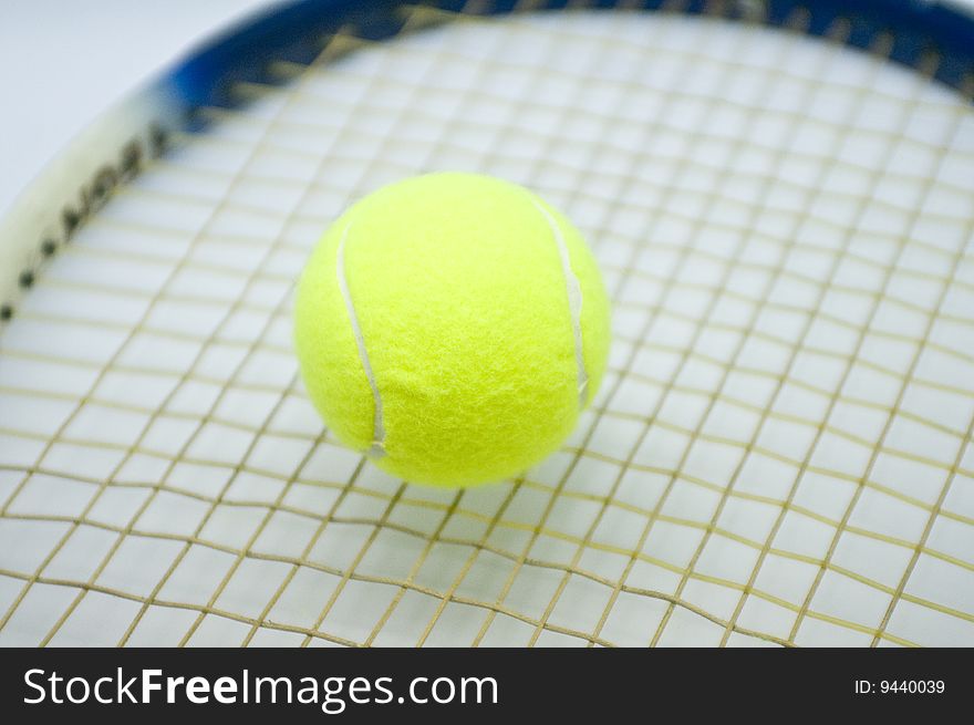 A tennis ball nestled on a raquet.