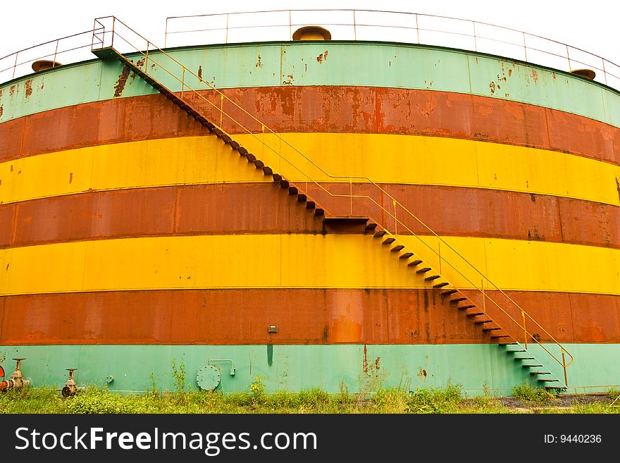 Deserted colorful oil tank with stair. Deserted colorful oil tank with stair