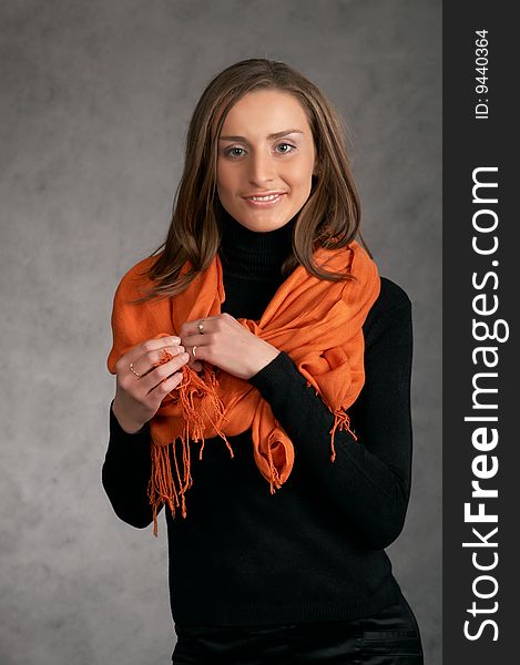 Model with a orange scarf on a grey background