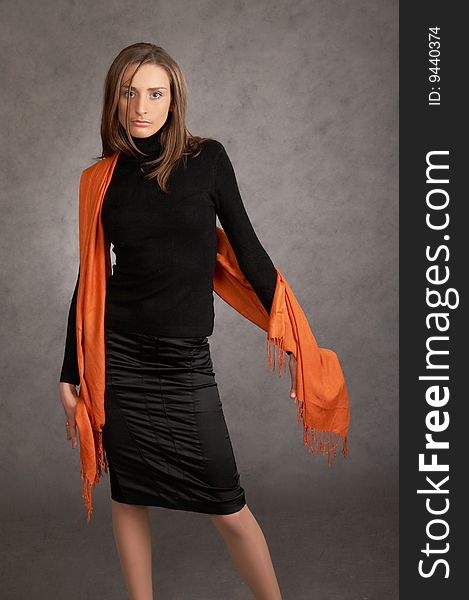 Model with a orange scarf on a grey background