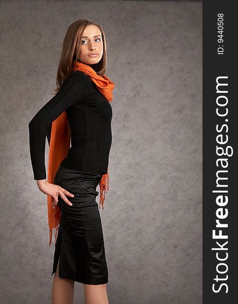 Model with a orange scarf on a grey background