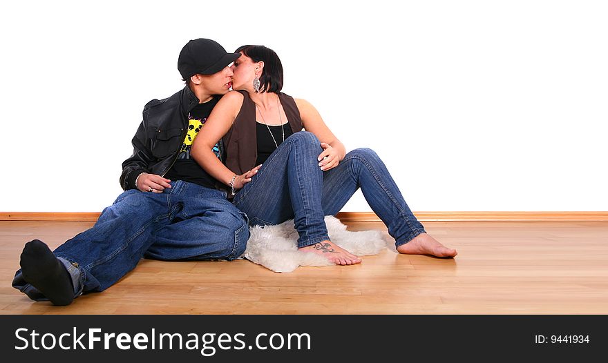 Young stylish couple kissing on the floor of their new home!