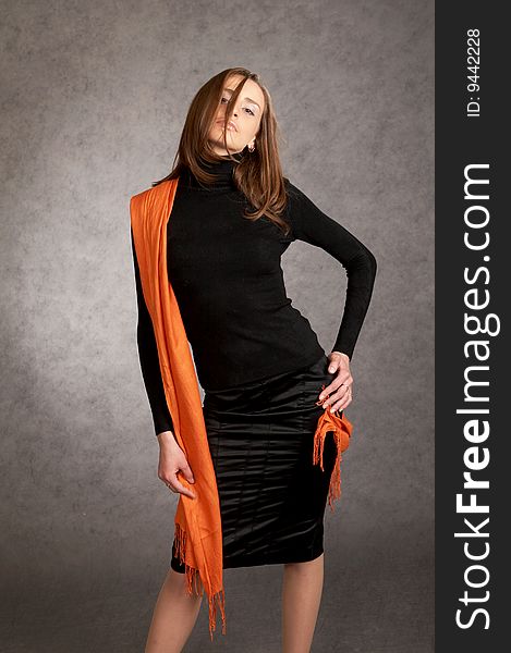 Fashion model with a orange scarf on a grey background