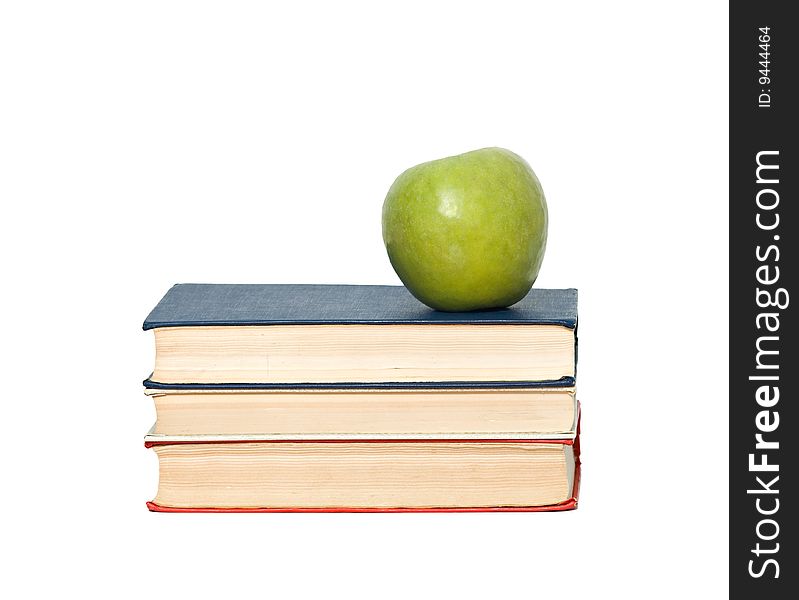 Green apple on pile of books on white background