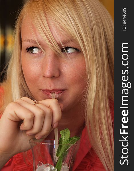 Smiling blond girl drinking closeup