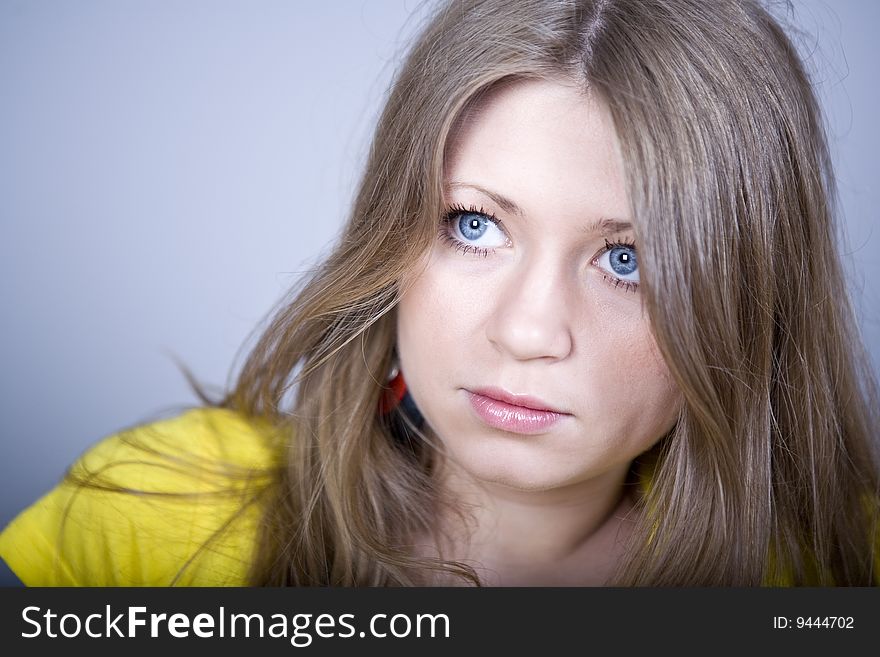 Blonde with blue eyes in a yellow sport shirt and ear-rings. Blonde with blue eyes in a yellow sport shirt and ear-rings