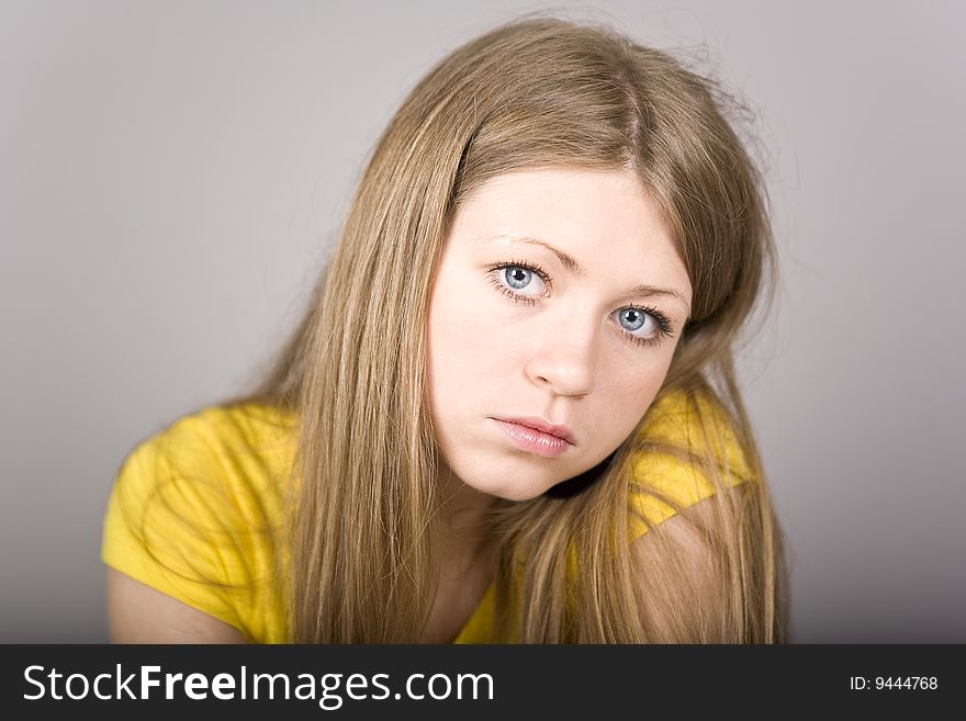 Blonde with blue eyes in a yellow sport shirt and ear-rings. Blonde with blue eyes in a yellow sport shirt and ear-rings