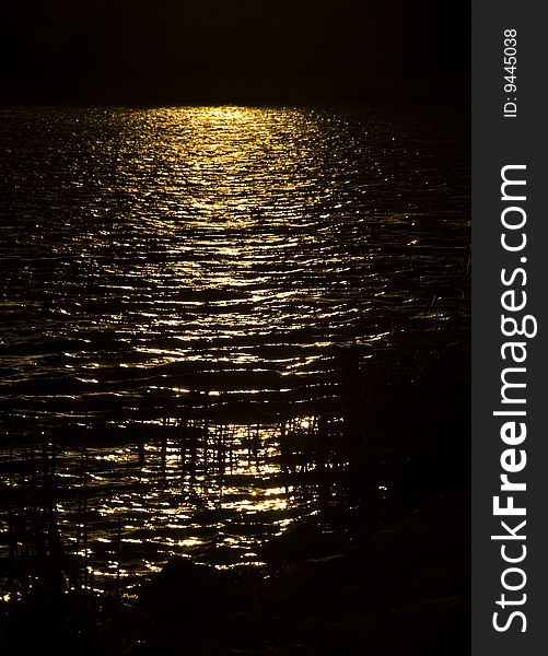 Golden sunbeam on dark lake in the northern Minnesota