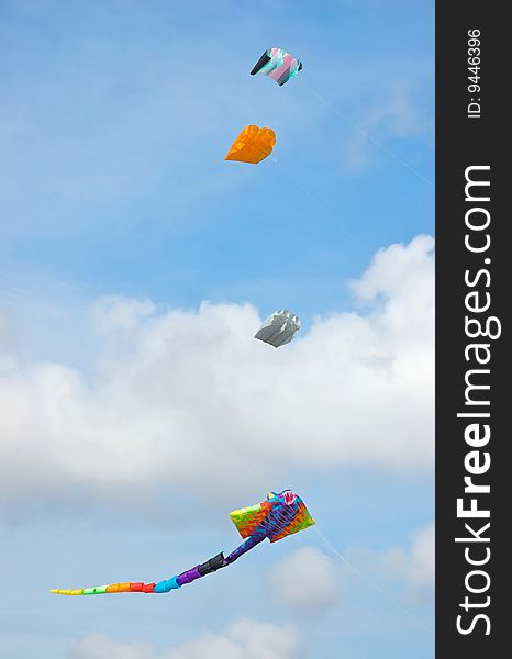 Several different kinds of kites flying in the sky