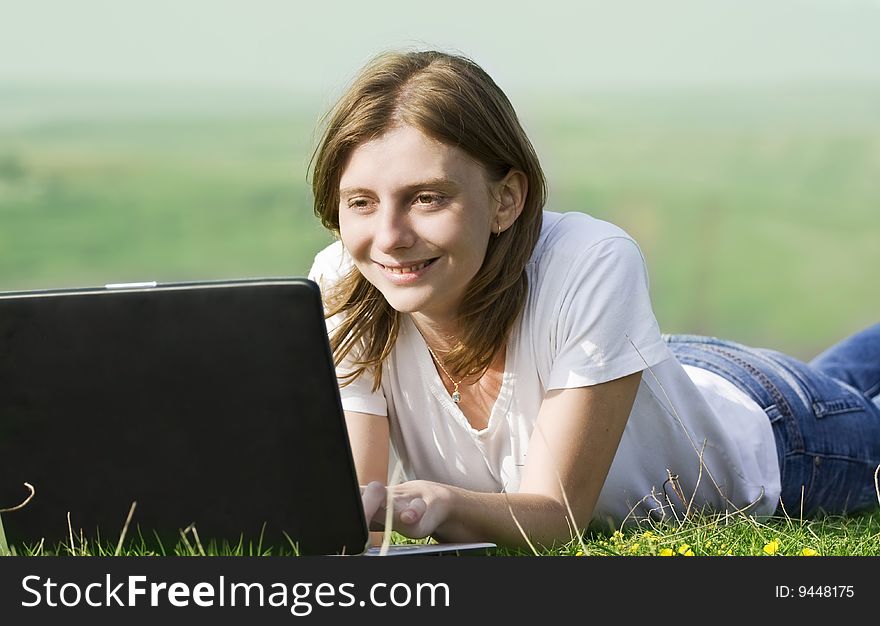 Young blonde girl working on laptop outdoors. Young blonde girl working on laptop outdoors
