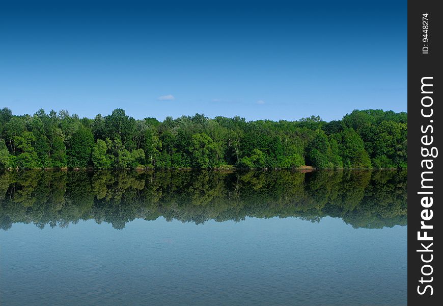 Forest landscape reflecting from the water. Forest landscape reflecting from the water