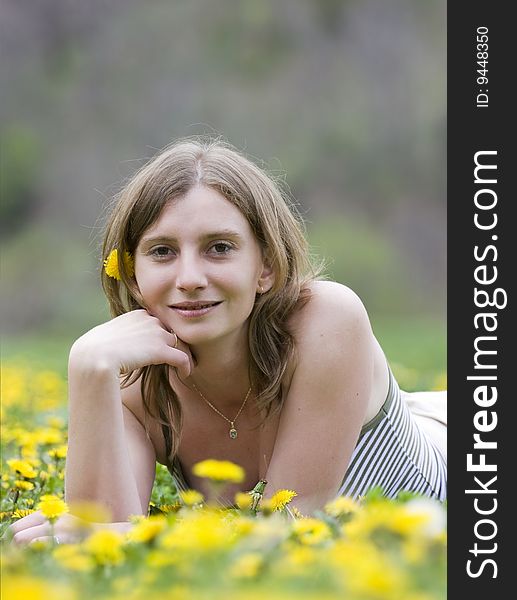 Blonde girl laying in a meadow with yellow flowers