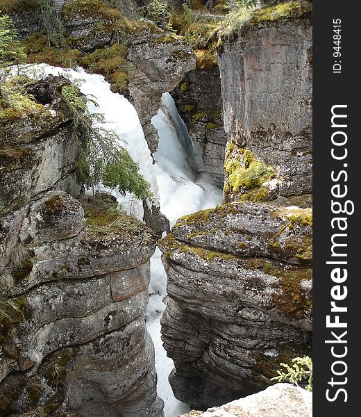 Close proximity of ancient rock shows the narrow channels where in Spring there is still snow in Maligne canyon, Alberta, Canada. Close proximity of ancient rock shows the narrow channels where in Spring there is still snow in Maligne canyon, Alberta, Canada