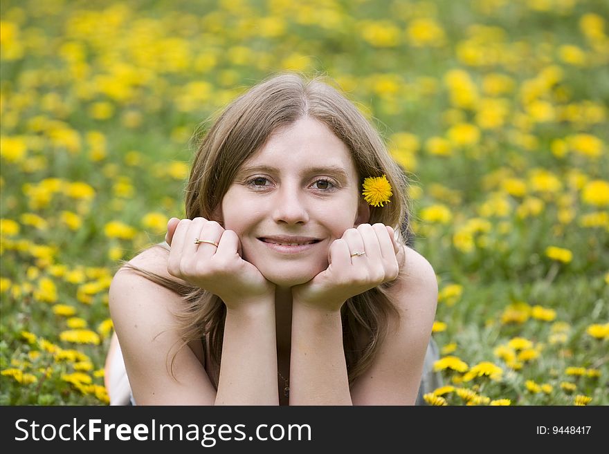 Blonde girl laying in a meadow with yellow flowers