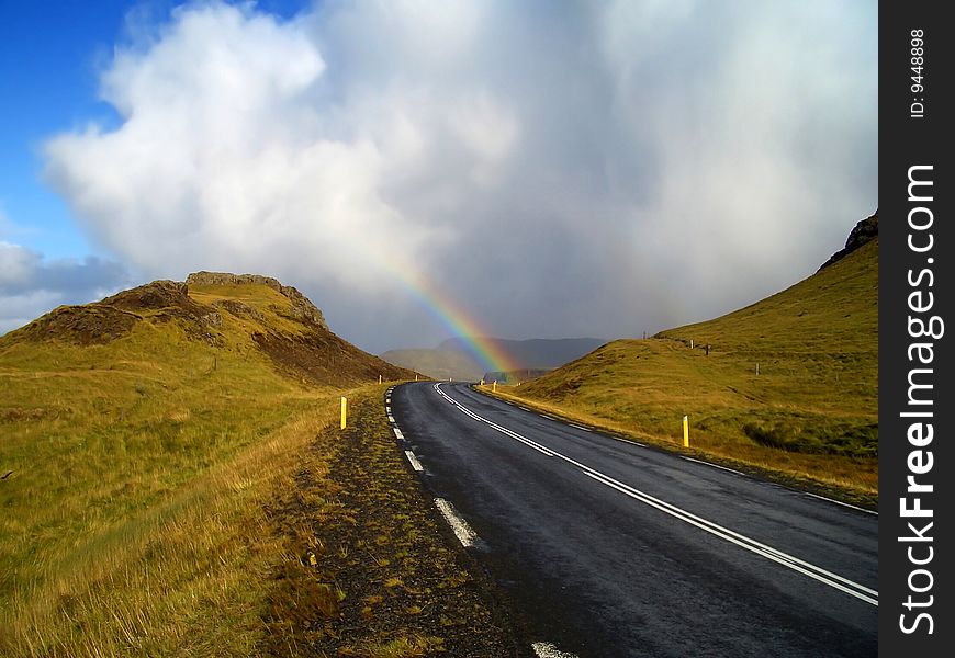 Rainbow over the road. Road around Hvalfjordur, Iceland. Rainbow over the road. Road around Hvalfjordur, Iceland.