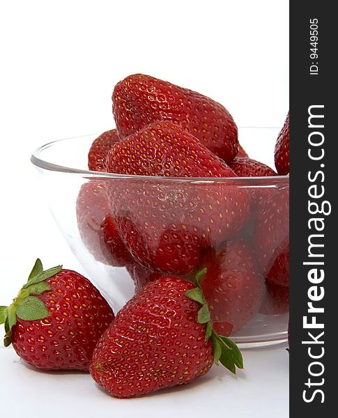 Ripe strawberries in a glass bowl on a white background. Ripe strawberries in a glass bowl on a white background