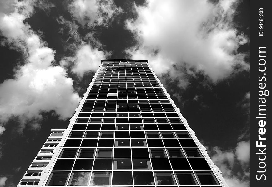 High rise modern building against cloudy skies in black and white. High rise modern building against cloudy skies in black and white.