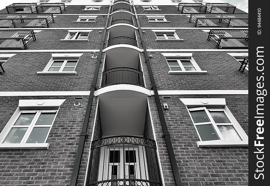 A monochrome of a residential building from a low angle.