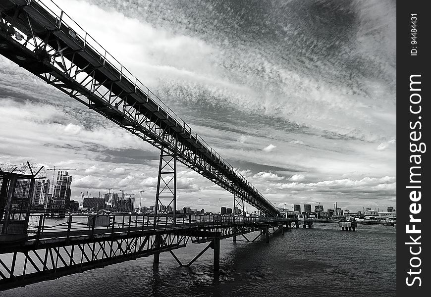 A monochrome of a steel bridge from a low angle. A monochrome of a steel bridge from a low angle.