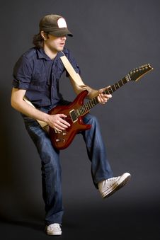Guitarist Playing His Guitar With One Leg Up Stock Photography